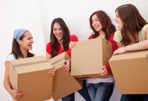 Moving truck and movers unloading boxes at a new home